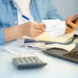 Woman,Using,A,Pen,Writing,On,Bank,Account,Book,While